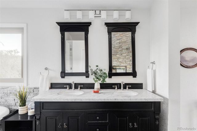 a bathroom with double sink and two mirror