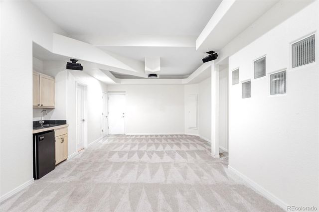 a view of a kitchen with a sink and a refrigerator