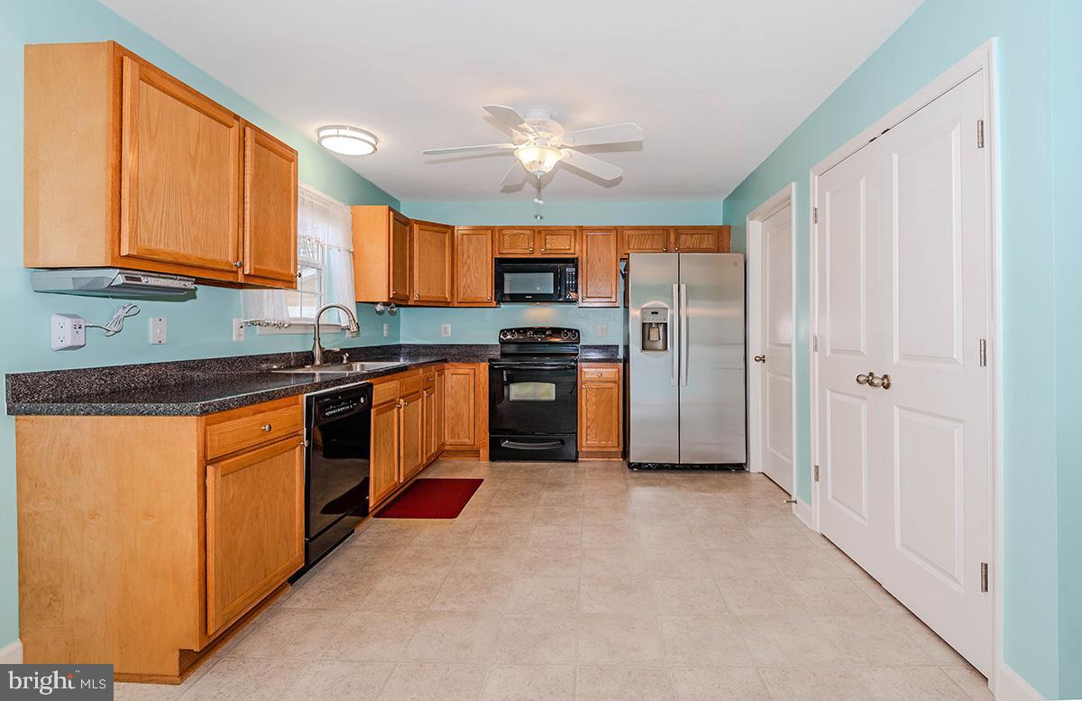 647 210th Street Pasadena, MD 21122 - Photo 12 of 44 a kitchen with stainless steel appliances granite countertop a stove top oven a sink and dishwasher