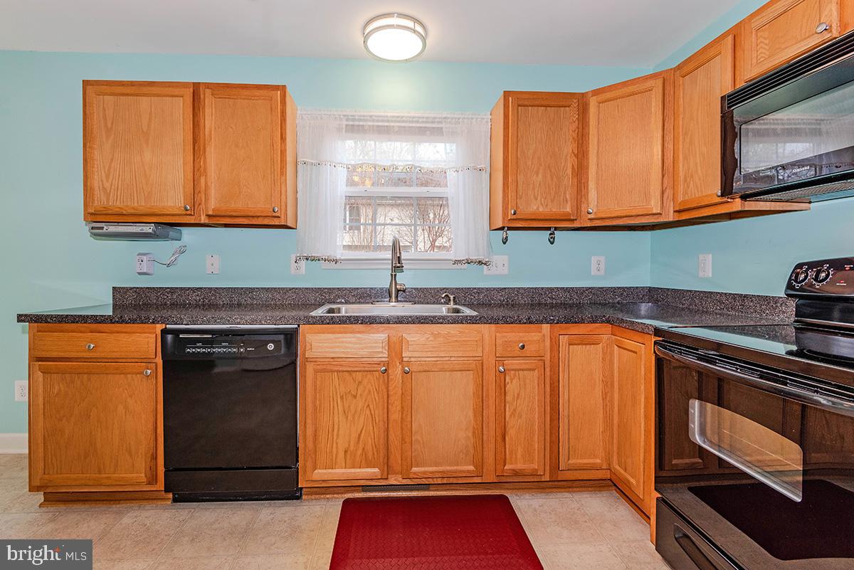 647 210th Street Pasadena, MD 21122 - Photo 13 of 44 a kitchen with granite countertop cabinets stainless steel appliances a sink and a window