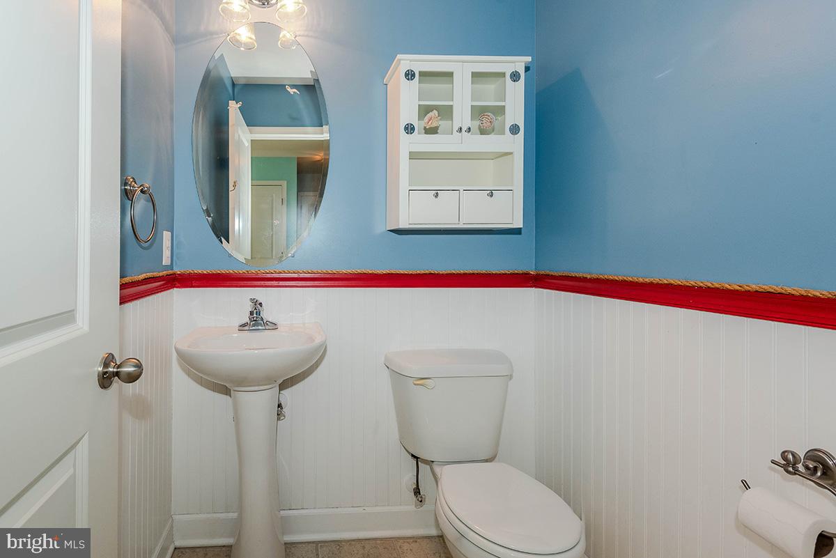 647 210th Street Pasadena, MD 21122 - Photo 15 of 44 a bathroom with a sink and mirror with toilet