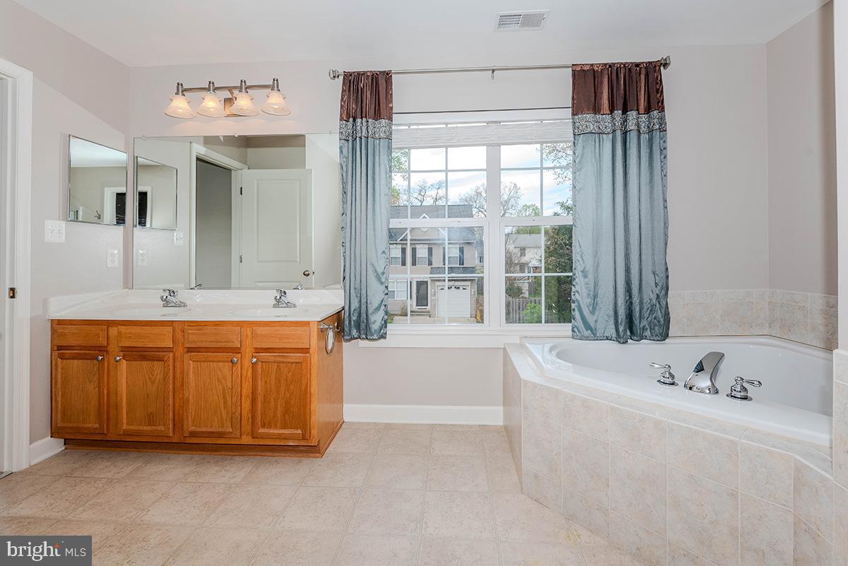 647 210th Street Pasadena, MD 21122 - Photo 19 of 44 a bathroom with a tub sink and mirror