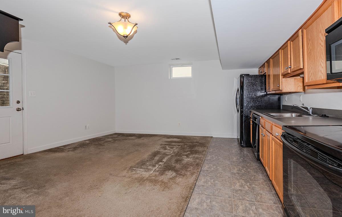 647 210th Street Pasadena, MD 21122 - Photo 26 of 44 a kitchen with a sink a stove and cabinets