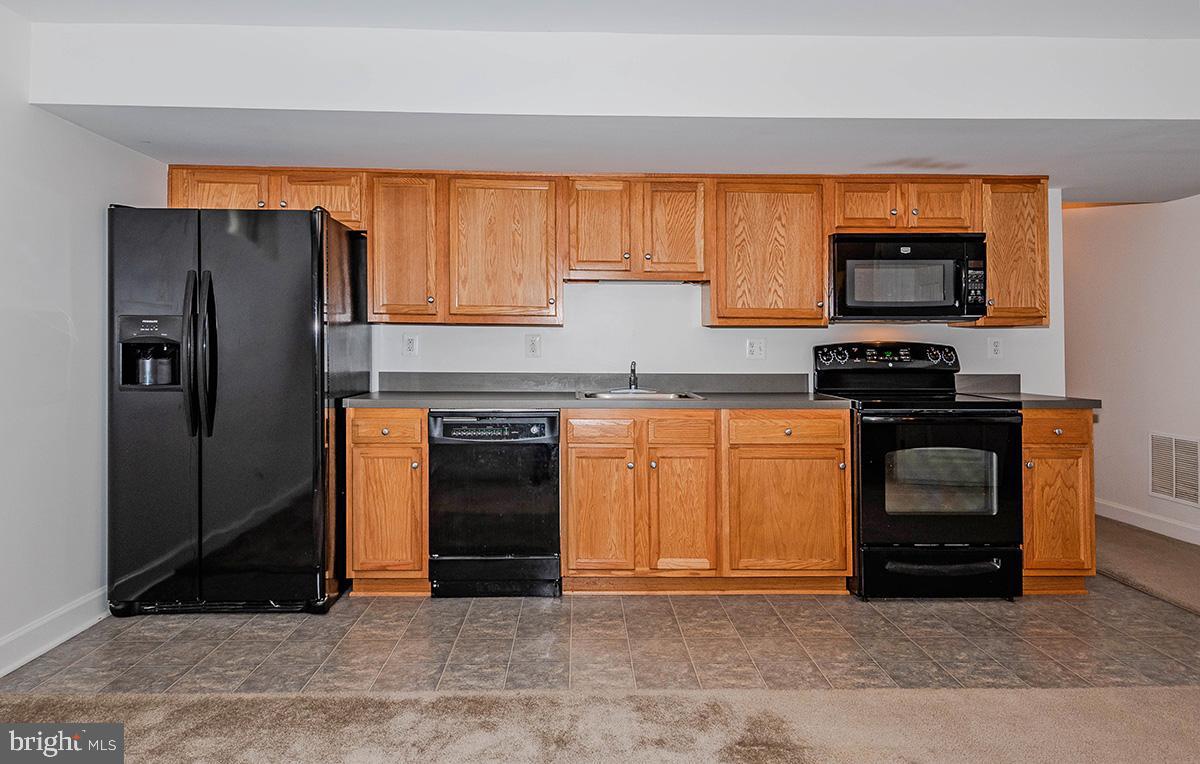 647 210th Street Pasadena, MD 21122 - Photo 30 of 44 a kitchen with granite countertop a refrigerator and a stove