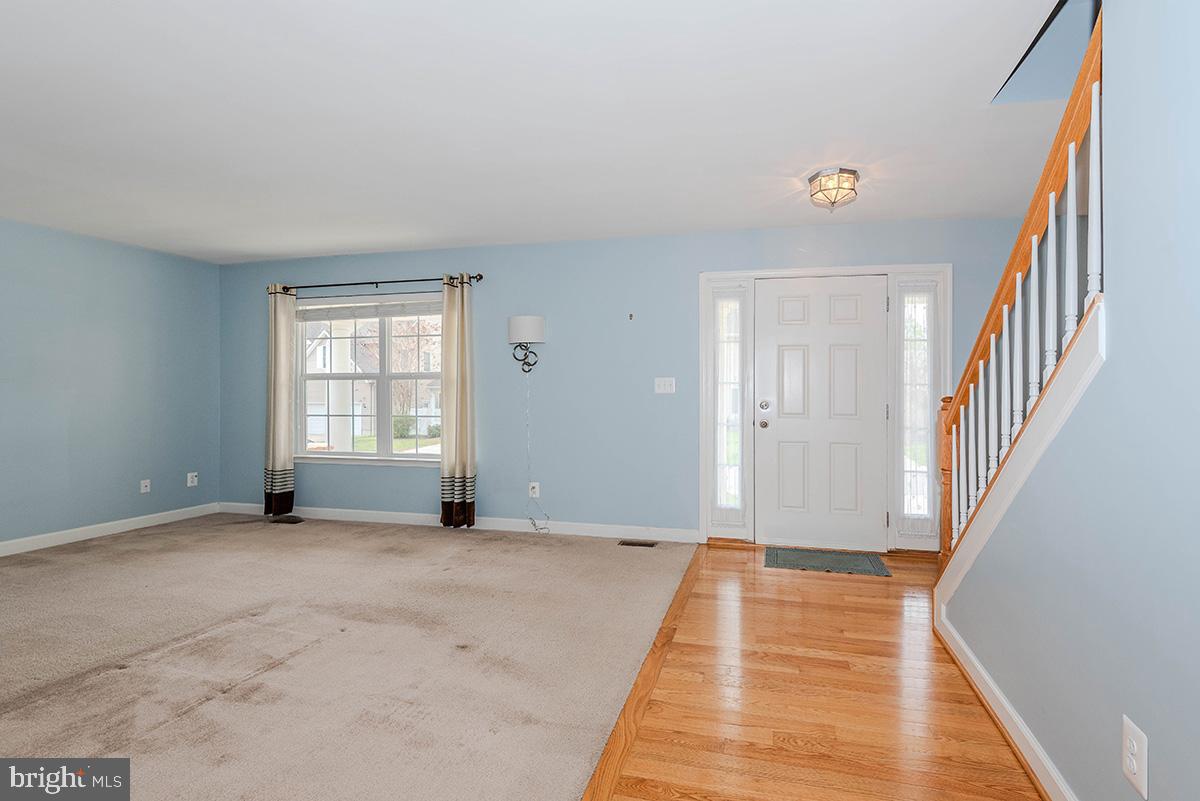 647 210th Street Pasadena, MD 21122 - Photo 5 of 44 a view of an empty room with wooden floor and a window