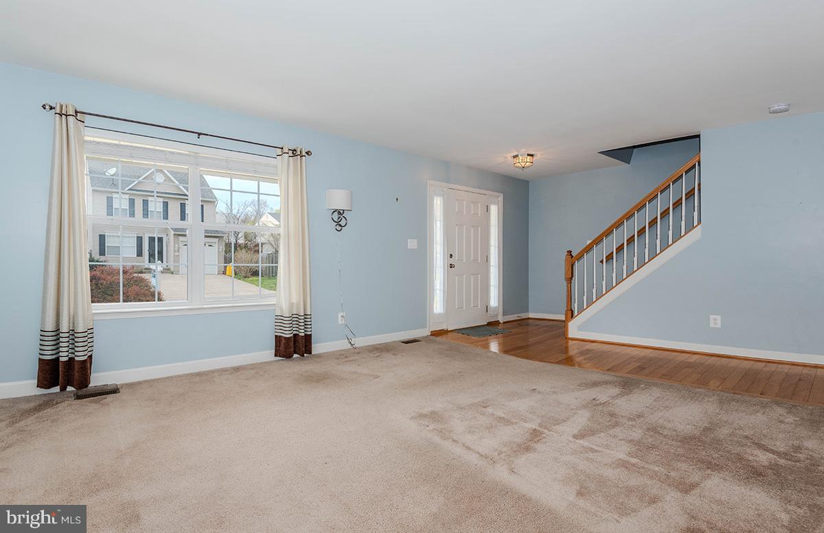 647 210th Street Pasadena, MD 21122 - Photo 8 of 44 a view of an empty room with wooden floor and windows