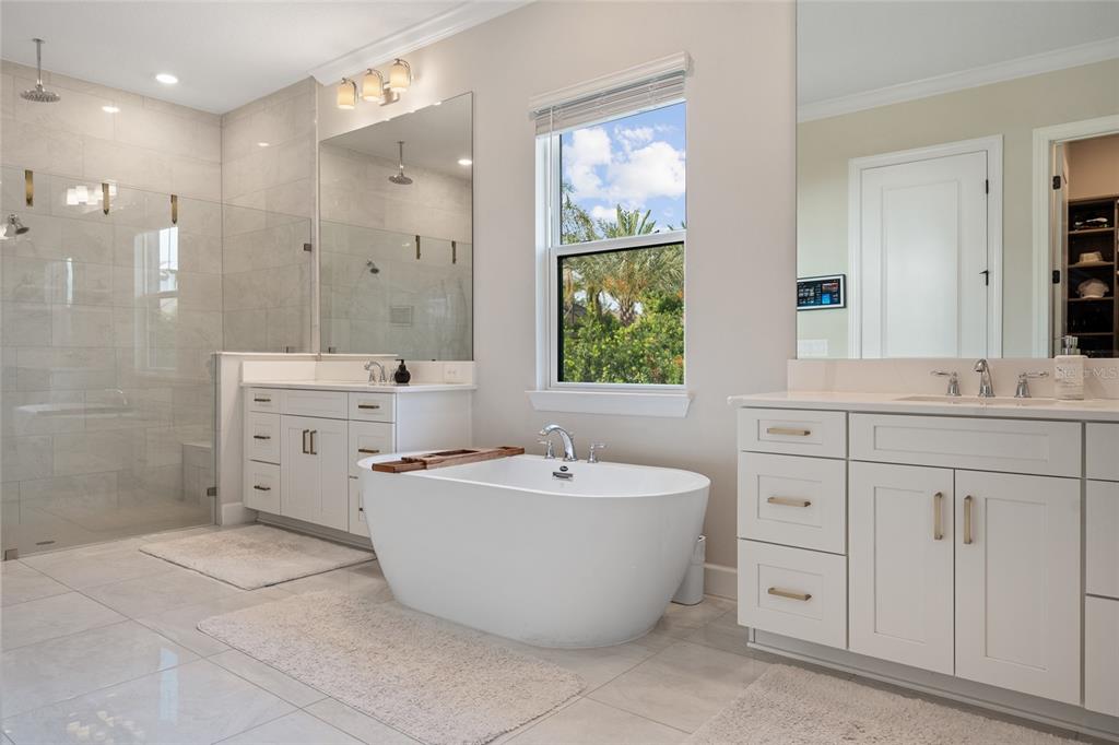 10175 Brocksport Circle Gotha, FL 34734 - Photo 20 of 54 a spacious bathroom with a double vanity sink a mirror and a bathtub