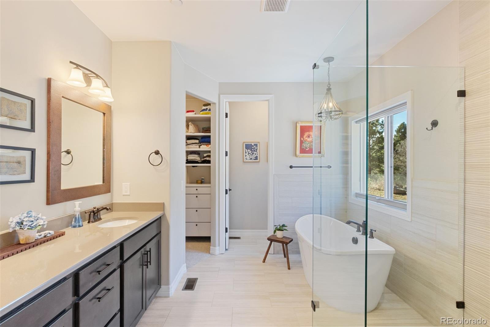 5318 Rocking Tree Grove Colorado Springs, CO 80906 - Photo 19 of 50 a spacious bathroom with a granite countertop sink mirror and shower