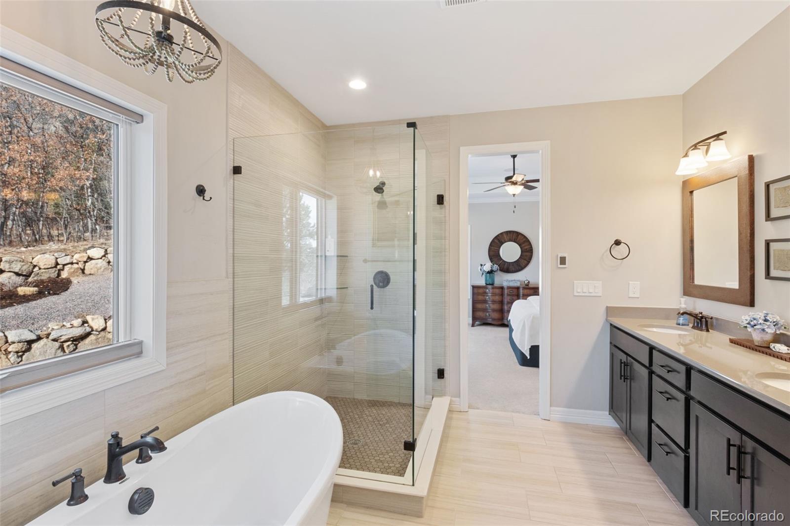 5318 Rocking Tree Grove Colorado Springs, CO 80906 - Photo 20 of 50 a spacious bathroom with a shower sink and mirror