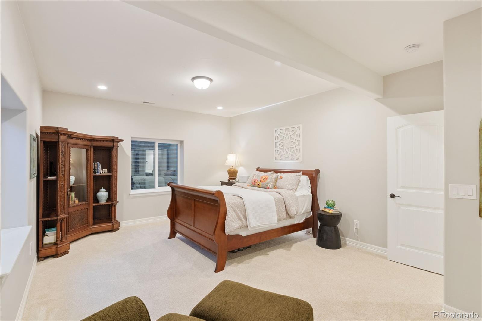 5318 Rocking Tree Grove Colorado Springs, CO 80906 - Photo 33 of 50 a spacious bedroom with a bed and glass door