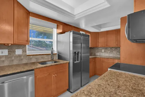 a kitchen with stainless steel appliances granite countertop a sink stove and refrigerator