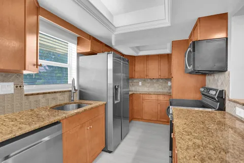 a kitchen with stainless steel appliances granite countertop a sink stove and refrigerator