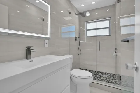 a bathroom with a sink a toilet and shower