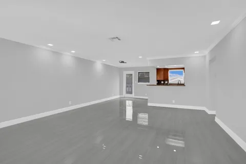 a view of a big room with wooden floor and windows