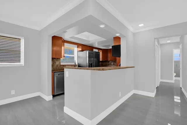a view of kitchen with stainless steel appliances granite countertop a stove and a sink