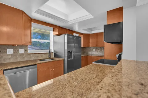 a kitchen with stainless steel appliances a sink stove and refrigerator