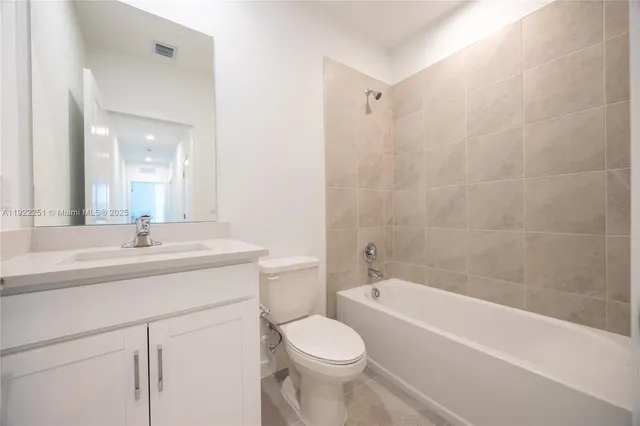 a bathroom with a granite countertop sink a toilet and shower