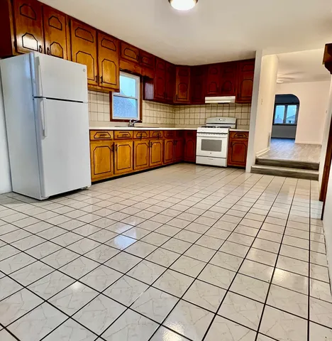 a kitchen with stainless steel appliances granite countertop a refrigerator sink and stove