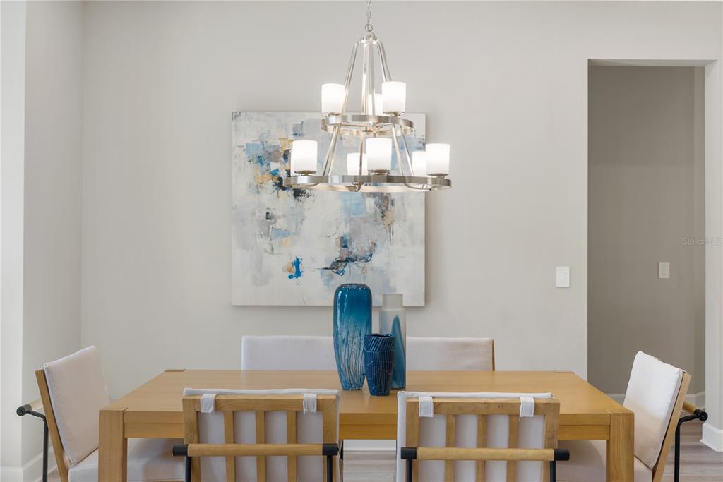 10199 Brocksport Circle Gotha, FL 34734 - Photo 17 of 82 a dining room with chandelier and wooden floor