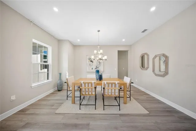 a kitchen with stainless steel appliances granite countertop a stove top oven a refrigerator a sink and chairs