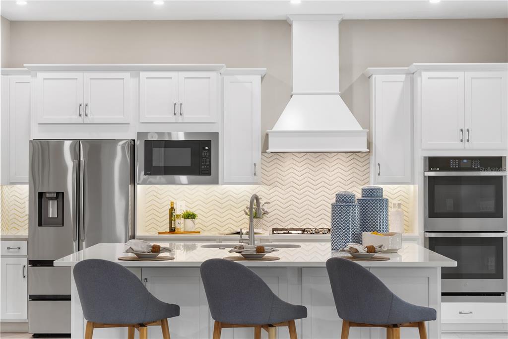 10199 Brocksport Circle Gotha, FL 34734 - Photo 24 of 82 a kitchen with stainless steel appliances granite countertop a stove top oven a refrigerator a sink and chairs