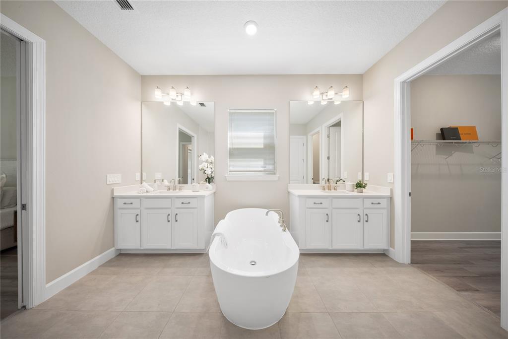 10199 Brocksport Circle Gotha, FL 34734 - Photo 39 of 82 a spacious bathroom with a double vanity sink a mirror and a bathtub
