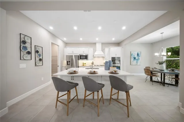 a dining room with furniture a chandelier and wooden floor