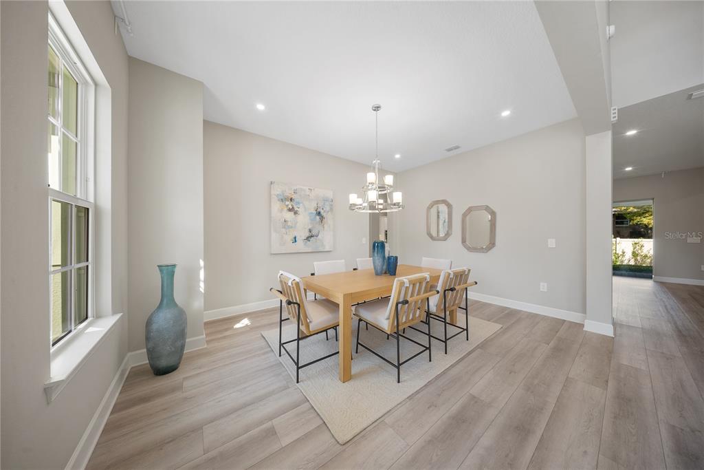 10199 Brocksport Circle Gotha, FL 34734 - Photo 7 of 82 a dining room with furniture a chandelier and wooden floor