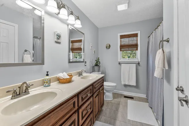 a en suite bathroom with a double vanity sink mirror and shower