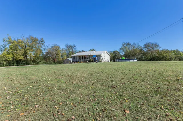 a view of a green field with trees in the background