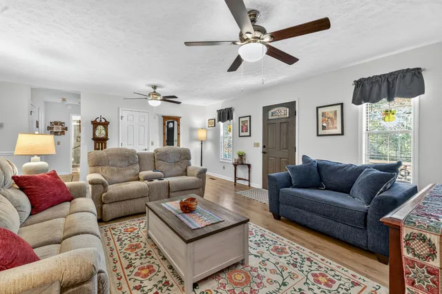 a living room with furniture a rug and a window