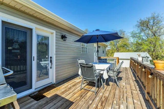 a view of deck with table and chairs under an umbrella with wooden floor