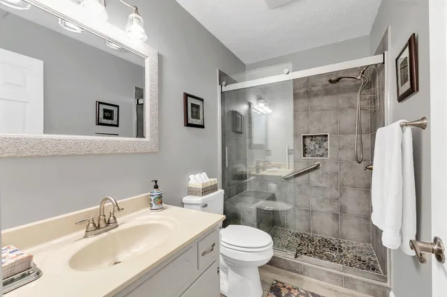 a bathroom with a sink toilet a mirror and shower