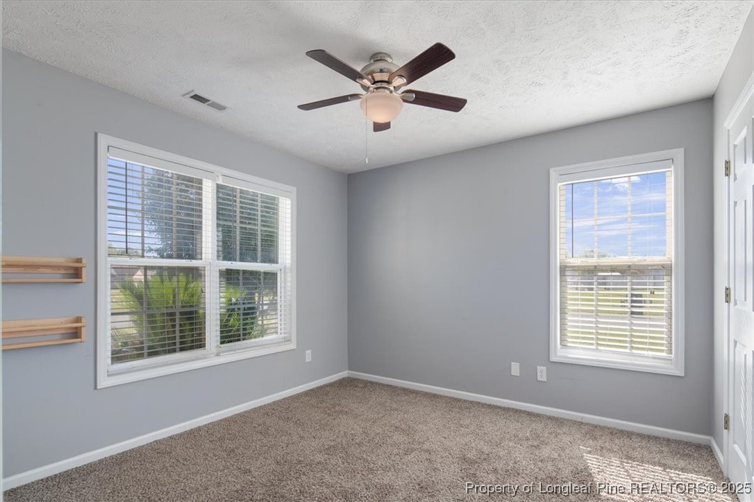 103 Beaumont Court Raeford, NC 28376 - Photo 38 of 50 an empty room with ceiling fan and windows