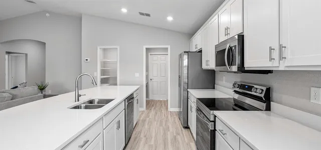 a kitchen with stainless steel appliances granite countertop a sink stove and refrigerator