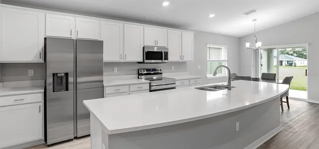 a kitchen with stainless steel appliances a refrigerator stove microwave and sink