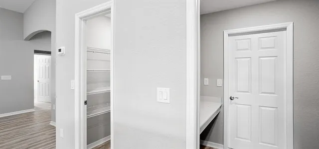 a view of a hallway with wooden floor and staircase