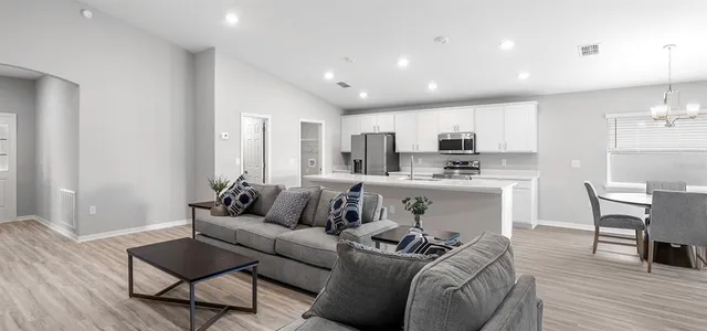 a living room with furniture and kitchen view