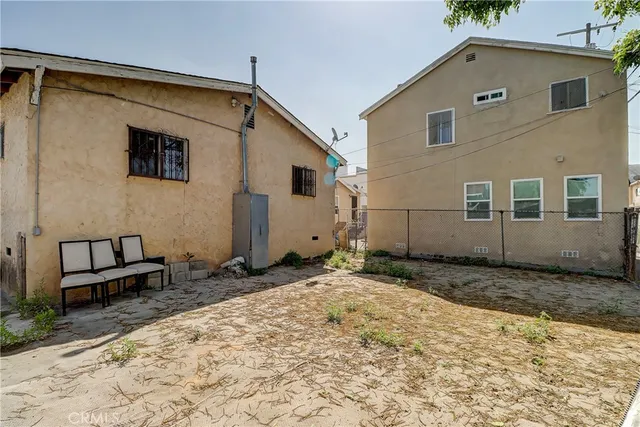 a backyard of a house with barbeque oven and wooden fence