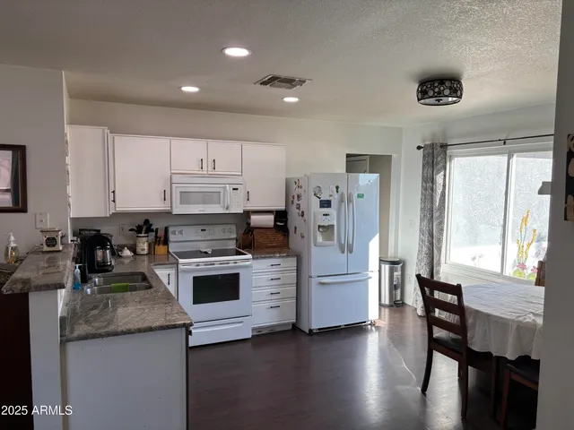 a kitchen with a refrigerator and a stove top oven