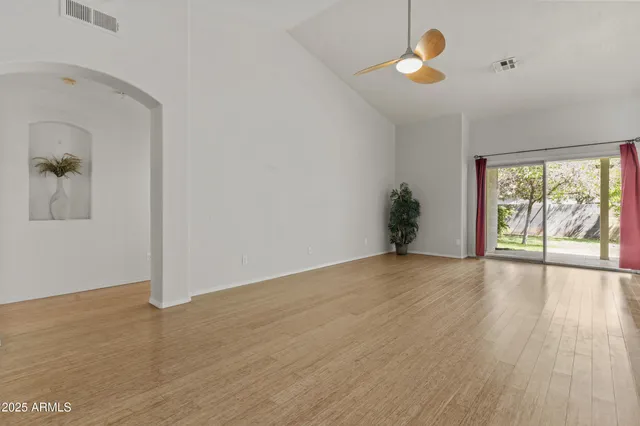 a view of an empty room with window and chandelier