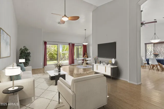 a living room with furniture a flat screen tv and a large window