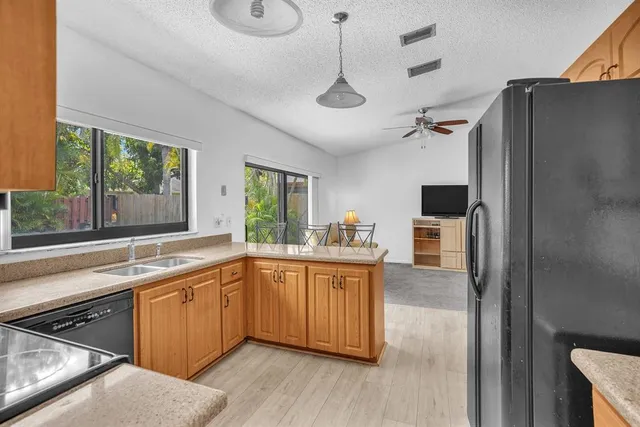a kitchen with stainless steel appliances granite countertop a sink a stove and refrigerator