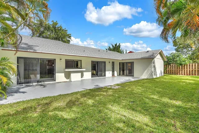 a front view of house with yard and glass windows