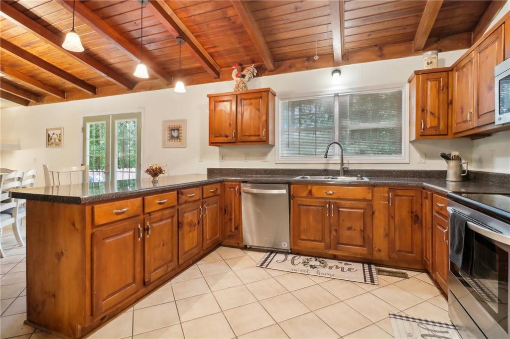 130 Carroll Street Temple, GA 30179 - Photo 12 of 30 a large kitchen with stainless steel appliances wooden cabinets a sink and a stove
