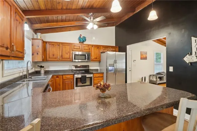 a kitchen with stainless steel appliances granite countertop a sink a stove counter space and refrigerator