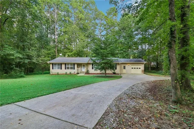 a view of a house with garden and trees