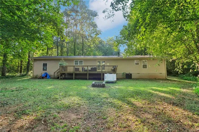 a view of a house with backyard and a tree