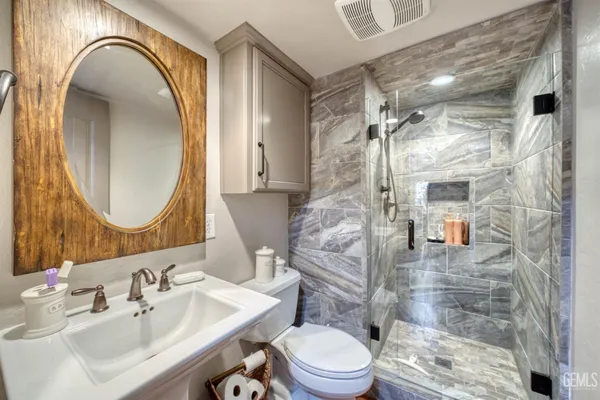 a bathroom with a sink a toilet and a mirror