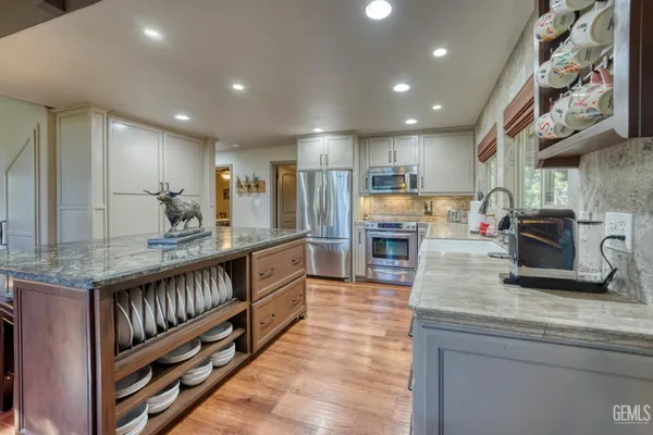 a kitchen with stainless steel appliances granite countertop a sink and cabinets